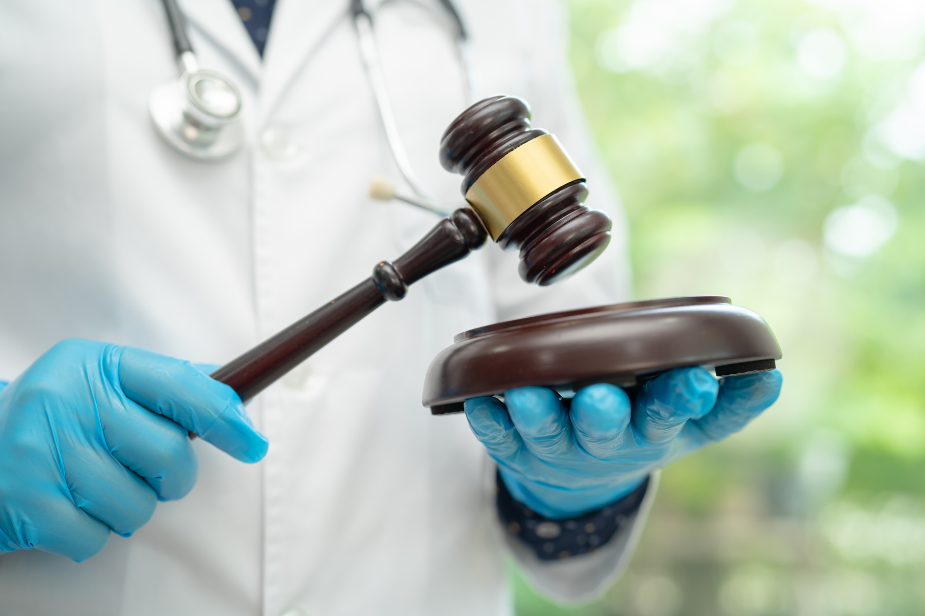 Doctor holding judge gavel, forensic medicine, medical law and c